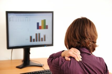 Business woman with neck pain sitting at computer